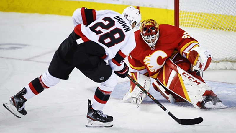 Ottawa Senators' Connor Brown, left, scores on Calgary Flames goalie Jacob Markstrom during third period NHL hockey action in Calgary, Thursday, Jan. 13, 2022.THE CANADIAN PRESS/Jeff McIntosh