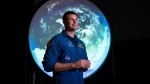 Canadian Space Agency astronaut Jeremy Hansen stands in front of a display as he participates in an interview at the opening of Earth in Focus: Insights from Space, a new exhibition at the Canada Science and Technology Museum in Ottawa, on Friday, Nov. 26, 2021. (THE CANADIAN PRESS / Justin Tang)