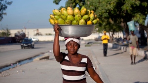A street vendor balances a bowl of mangos in Port-au-Prince, Haiti, Wednesday, Dec. 9, 2015. She sells five mangos for $2 dollars. (AP Photo/Dieu Nalio Chery) 