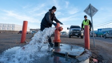 Members of the Iqaluit Fire Department assist with flushing the city's water pipes in Iqaluit, Nunavut, on Wednesday, Oct. 27, 2021. THE CANADIAN PRESS/Dustin Patar 