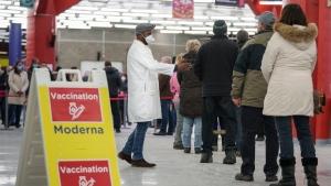 People line up to enter a COVID-19 vaccination clinic in Montreal, on Thursday, January 6, 2022. THE CANADIAN PRESS/Paul Chiasson