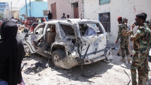 Security forces observe the remains of the vehicle in which he was travelling after Somalia's government spokesperson Mohamed Ibrahim Moalimuu was wounded in a suicide bombing in Mogadishu, Somalia Sunday, Jan. 16, 2022. (AP Photo/Farah Abdi Warsameh) 