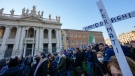 A woman holds a cross that reads 'Mario Draghi Stop' as people stage a protest against the COVID-19 vaccination Green Pass, in Rome, Saturday, Jan. 15, 2022. (AP Photo/Andrew Medichini)