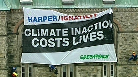 Greenpeace protesters unfurl a banner targeting on the Parliament Buildings in Ottawa Monday, Dec. 7, 2009.
