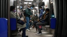 People wearing face masks to protect against COVID-19 ride a subway in Paris on Jan. 14, 2022. (AP Photo/Michel Euler)