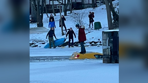 Tetangga menggunakan kayak untuk menyelamatkan pengemudi setelah mobil menabrak es di Manotick, Ontario.