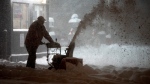 A man clears snow at a gas station during a winter storm in Toronto on Monday January 17, 2022. THE CANADIAN PRESS/Frank Gunn 
