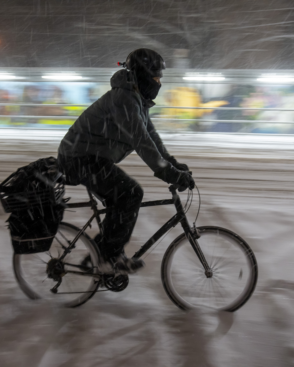 A cyclist rides through a winter storm 