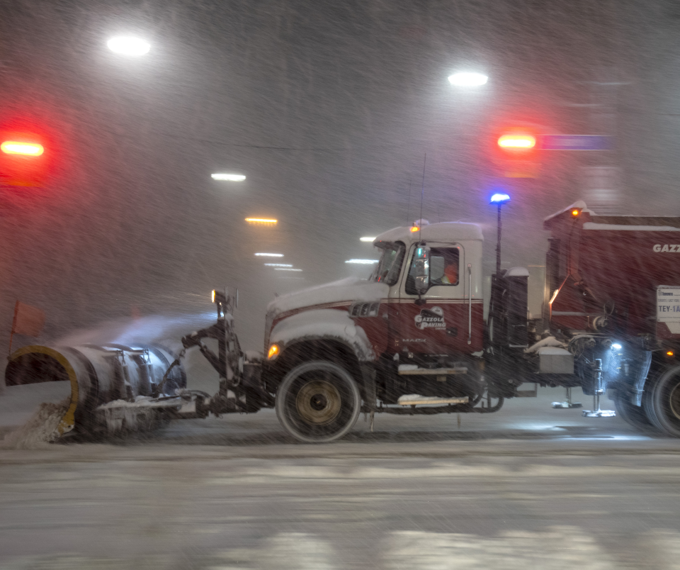 A snow plow clears streets