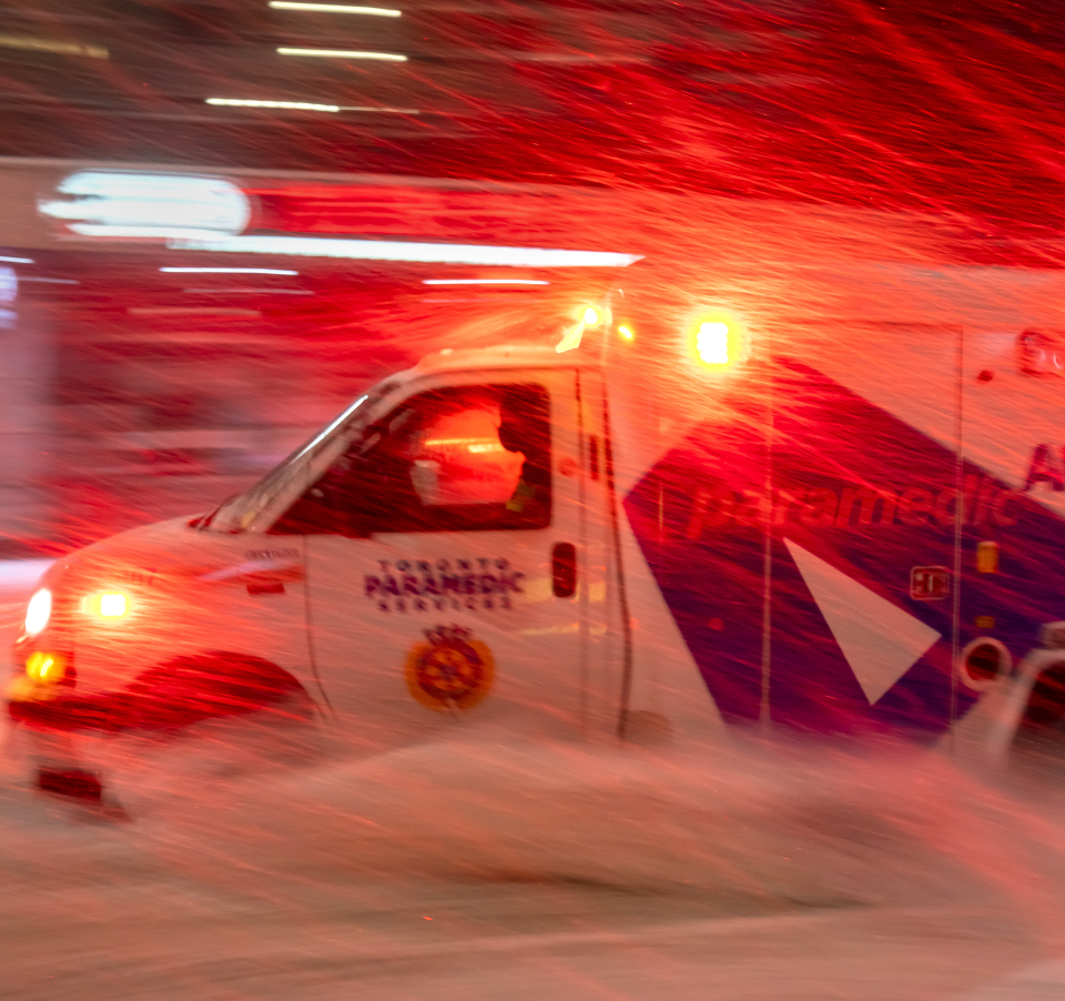 An ambulance races through a winter storm
