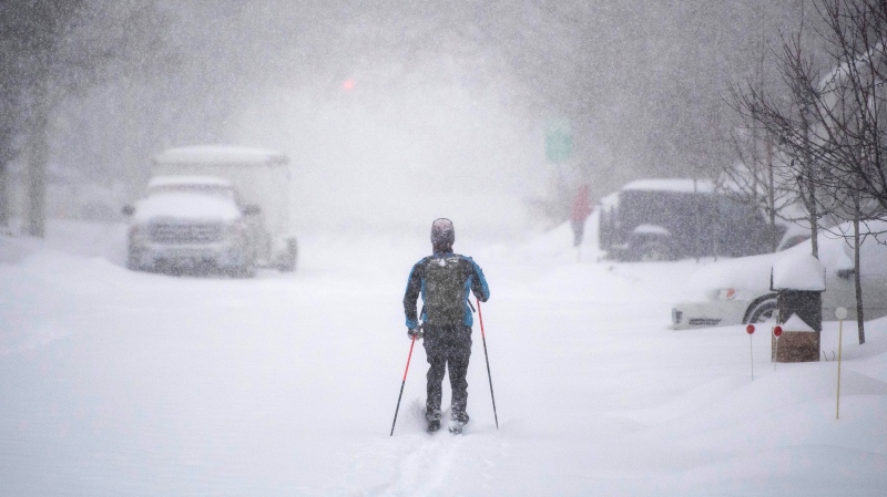 A cross-country skier makes their way up a snow-covered road in Ottawa, on Monday, Jan. 17, 2022. A blizzard warning is in effect for the region with Environment Canada predicting between 25 to 40 cm of snow. (Justin Tang/THE CANADIAN PRESS)