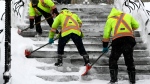Crews clear snow from the steps in front of West Block on Parliament Hill in Ottawa during a winter storm on Monday, Jan. 17, 2022. (Justin Tang/THE CANADIAN PRESS)