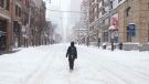 A woman makes her way along a street in downtown Toronto as a heavy snowfall affects the greater Toronto area on Monday January 17, 2022. THE CANADIAN PRESS/Chris Young