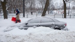 A car remains behind a snowbank in downtown Toronto as a heavy snowfall affects the greater Toronto area on Monday January 17, 2022. THE CANADIAN PRESS/Chris Young 