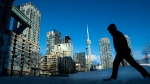 Condo towers dot the Toronto skyline as a pedestrian makes his way through the COVID-19 restricted winter landscape on Thursday January 28, 2021. THE CANADIAN PRESS/Frank Gunn 