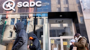 People walk by an SQDC store in Montreal, Saturday, January 15, 2022, as the COVID-19 pandemic continues in Canada. As of Monday, people wishing to purchase cannabis products or alcohol from an SAQ outlet must show a COVID-19 vaccine passport. THE CANADIAN PRESS/Graham Hughes 