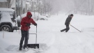 People work to clear their driveways as heavy snow continues to fall in Ottawa, on Monday, Jan. 17, 2022. A blizzard warning is in effect for the region with Environment Canada predicting between 25 to 40 cm of snow. (THE CANADIAN PRESS/Justin Tang )