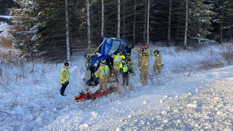 Ottawa firefighters help extricate a woman trapped in her pickup truck after it rolled into a ditch along Highway 417 between Hunt Club and Ramsayville roads Jan. 18, 2022. (Ottawa Fire Service/handout)