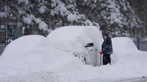 A man tries to dig his truck out from the snow after a major snow storm in Mississauga, Ont., on Monday, January 17, 2022. THE CANADIAN PRESS/Nathan Denette 
