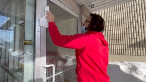 Ogilvie Pizza owner Hani Soueid cleaning his new door. His door was smashed by a robber, but it was replaced free of charge after word of Soueid's act of kindness for a customer made headlines. (Dave Charbonneau/CTV News Ottawa)