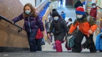 Students rush into an elementary school on Tuesday, January 18, 2022. THE CANADIAN PRESS/Paul Chiasson 
