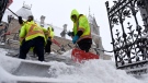 Crews clear snow from the steps in front of West Block on Parliament Hill in Ottawa during a winter storm on Jan. 17, 2022. (Justin Tang / THE CANADIAN PRESS)