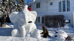 Snow carvers Madeleine Vrignon and Gary Tessier put the final touches on a Dumbo snow scuplture on a Winnipeg lawn (Zachery Kitchen, CTV News)
