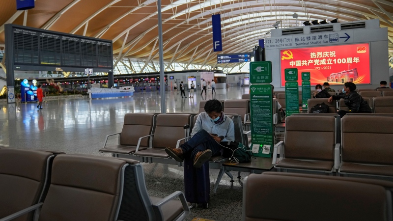 Passengers wearing face masks to help protect against the coronavirus take rest at Pudong International Airport in Shanghai, China on July 25, 2021. (AP Photo/Andy Wong, File) 