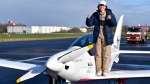 Teenage pilot Zara Rutherford poses with the thumbs up after landing her Shark ultralight plane at the Kortrijk airport in Kortrijk, Belgium, Thursday, Jan. 20, 2022. (AP Photo/Geert Vanden Wijngaert) 