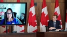 Minister of Crown-Indigenous Relations Marc Miller and Executive Director of the National Centre for Truth and Reconciliation Stephanie Scott (virtually on monitor) listen to a question from media during a press conference in Ottawa on Thursday, Jan. 20, 2022. THE CANADIAN PRESS/Sean Kilpatrick 