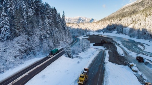 A transport truck hauling pipe travels on the Coquihalla Highway after it was reopened to commercial traffic as heavy equipment is used to rebuild the southbound lanes that were washed away by flooding last month at Othello, northeast of Hope, B.C., on Monday, Dec. 20, 2021. (Darryl Dyck / THE CANADIAN PRESS)