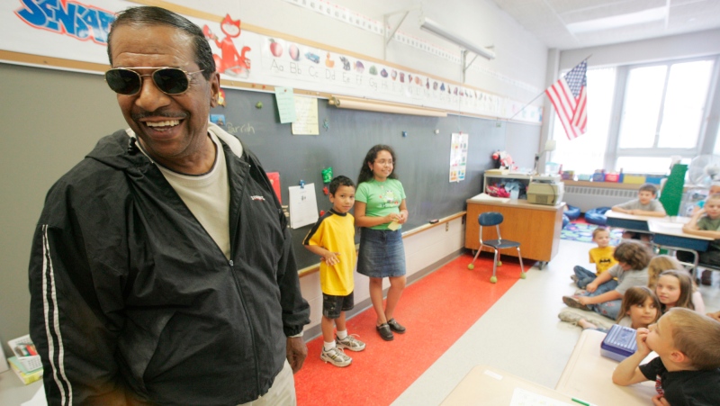 Singer Fred Parris, famous for singing "In the Still of the Night," with the 1950s harmony group The Five Satins, is introduced by his grandchildren Brandon Parris, 7, background left, and Savannah Parris, 9, during a visit to Hanover Elementary School in Meriden, Conn., on June 16, 2005. (Chris Angileri/Record-Journal via AP, File) 