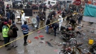 Police officials and investigators examine the site of bomb explosion, in Lahore, Pakistan, Thursday, Jan. 20, 2022. (AP Photo/K.M. Chaudary)