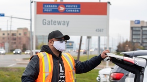 A Canada Post employee puts his bag in his trunk as he leaves the Gateway facility in Mississauga, Ontario on Wednesday April 28, 2021. THE CANADIAN PRESS/Frank Gunn 