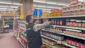 Gordon Dean stocking shelves at his grocery store in Chesterville, Ont. (Dave Charbonneau/CTV News Ottawa) 