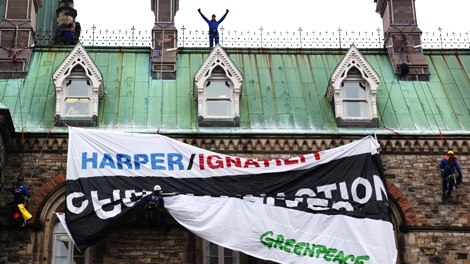 Greenpeace protester drapes a banner on the Parliament buildings in Ottawa, Monday, Dec. 7, 2009. (Fred Chartrand / THE CANADIAN PRESS)  