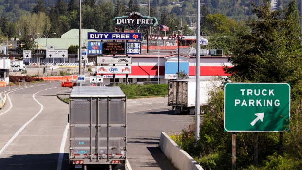 Trucks enter as most lanes remain closed at a border crossing into Canada from the U.S. on May 7, 2020, in Blaine, Wash.. (AP Photo/Elaine Thompson)