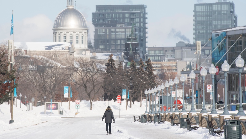 A person walks along the promenade in the Old Port in Montreal, Friday, Jan. 21, 2022. Environment Canada has issued an extreme cold warning for the region. THE CANADIAN PRESS/Graham Hughes 