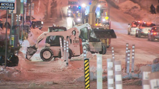 City crews are shown hauling away snow along Bloor Street on Thursday night.