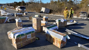 Crates holding live monkeys are scattered across the westbound lanes of state Route 54 at the junction with Interstate 80 near Danville, Pa., Friday, Jan. 21, 2022, after a pickup pulling a trailer carrying the monkeys was hit by a dump truck. They were transporting 100 monkeys and several were on the loose at the time of the photo. (Jimmy May/Bloomsburg Press Enterprise via AP) 