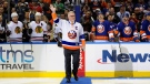 Former New York Islander Clark Gillies waves to fans before he dropped a ceremonial puck before the Islanders' NHL hockey game against the Chicago Blackhawks at Nassau Coliseum on Dec. 13, 2014, in Uniondale, N.Y. (AP Photo/Kathy Kmonicek, File)