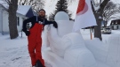 Bradley Gerbrandt stands next to his snow astronaut (Dan Timmerman, CTV News)