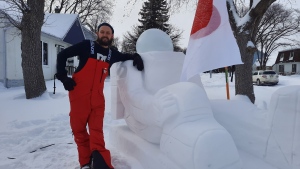 Bradley Gerbrandt stands next to his snow astronaut (Dan Timmerman, CTV News)