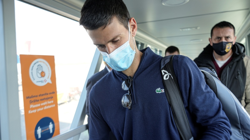 Novak Djokovic looks as his documents after landing in Belgrade, Serbia, Monday, Jan. 17, 2022. Djokovic arrived in the Serbian capital following his deportation from Australia on Sunday after losing a bid to stay in the country to defend his Australian Open title despite not being vaccinated against COVID-19.(AP Photo / Darko Bandic) 
