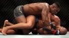Ngannou grapples on the ground with Gane. (Katelyn Mulcahy/Getty Images/CNN)