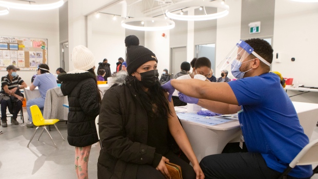 Dr. Kevin Evelyn of UHN gives a COVID-19 vaccine at a "Kids and Families Vaccine Clinic" operated by Black Creek Community Health Centre and hosted by Jane and Finch EarlyON child and Family Centre in the Jane and Finch Mall in Toronto on Thursday, January 13, 2022. THE CANADIAN PRESS/Chris Young 