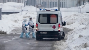 Medical workers walk to an ambulance at a hospital in Kommunarka, outside Moscow, Russia, Sunday, Jan. 23, 2022. (AP Photo/Alexander Zemlianichenko) 