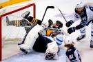 Pittsburgh Penguins' Sidney Crosby, top center rear, collides with Winnipeg Jets goaltender Connor Hellebuyck, bottom, during the overtime period of an NHL hockey game in Pittsburgh, Sunday, Jan. 23, 2022. The Penguins won in a shootout 3-2. (AP Photo/Gene J. Puskar)