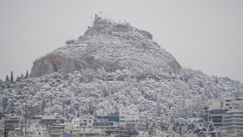 The city of Athens with the Lycabettus hill is covered with snow during a snowfall, on Monday, Jan. 24, 2022.  (AP Photo/Thanassis Stavrakis) 