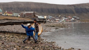 Children skip stones in Arctic Bay, Nunavut, on August 25, 2014. (Adrian Wyld / THE CANADIAN PRESS)